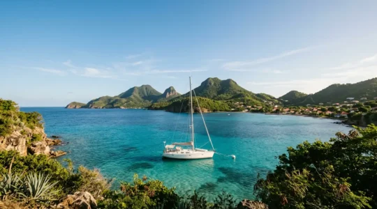 Voilier amarré sur bouée dans la baie cristalline des Saintes avec vue sur les îlets caribéens